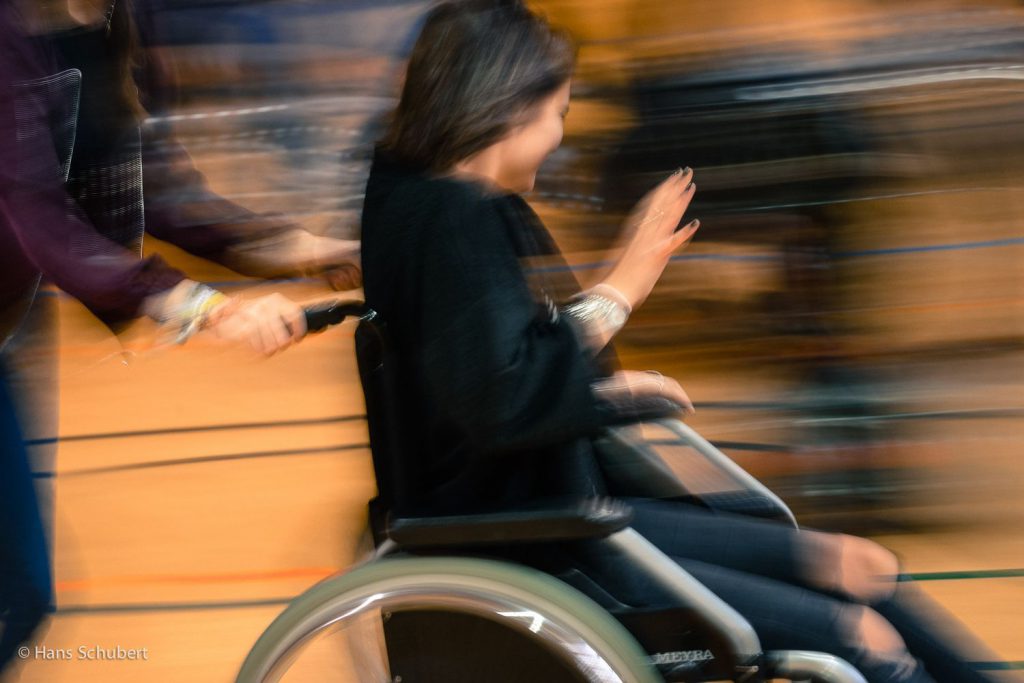 Elektrisierende, schnelle Moves, in der ein unscharfes Foto von einer Jugendlichen im Rollstuhl entsteht